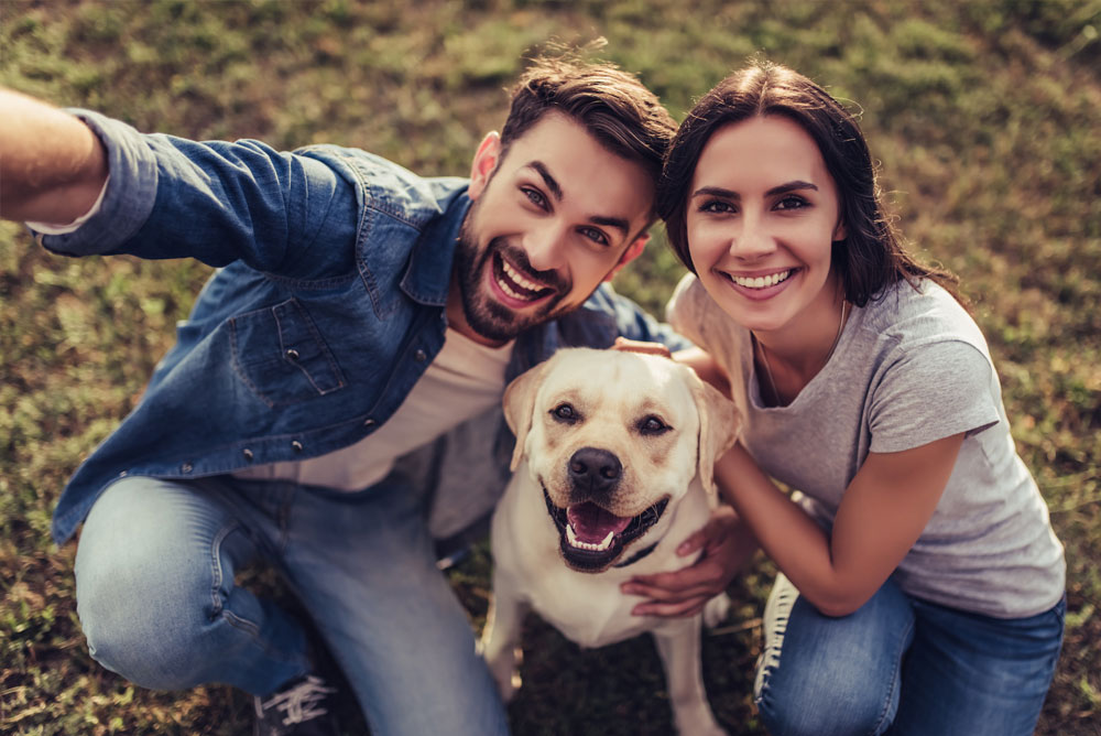 Smiling young couple with dog
