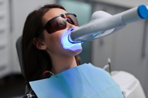 woman in dental chair receiving dental whitening treatment