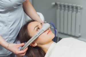 woman is fitted with mask for dental sedation